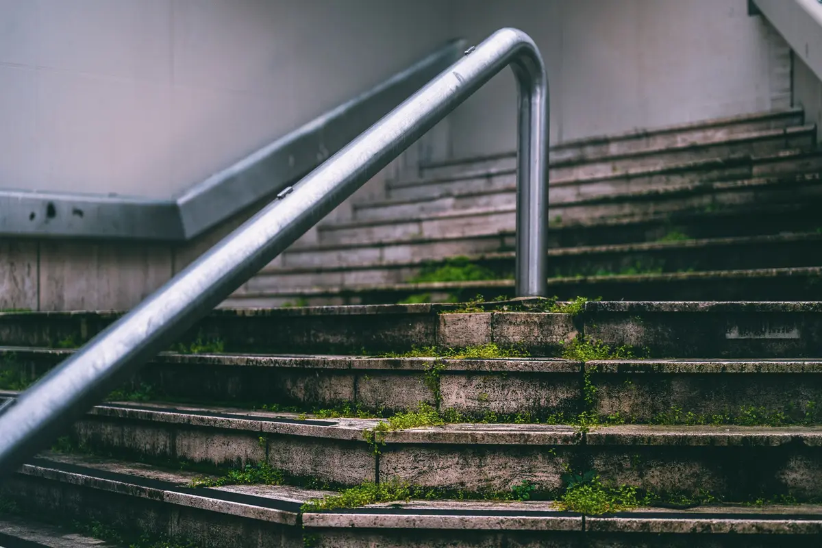 Escalera recta de hormigón con un pasamanos metálico
