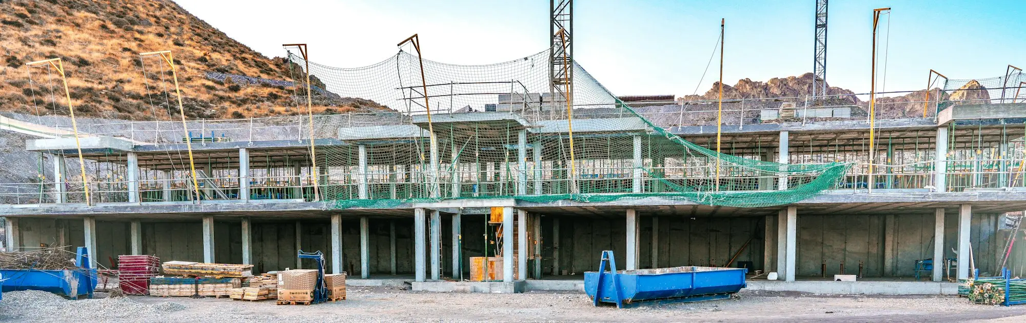 Edificio en construcción con la estructura de hormigón terminada y redes de seguridad